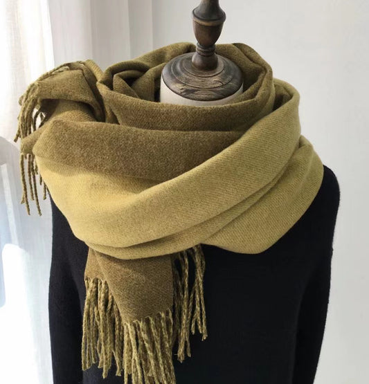 Green scarf with fringes on a mannequin against a white background