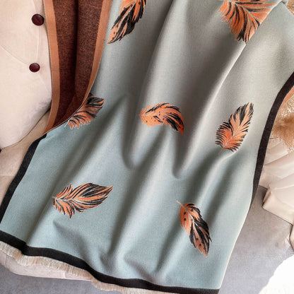 Light blue fabric with orange feather patterns draped over a neutral-colored garment.