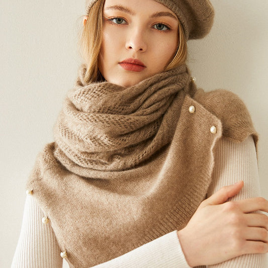 Woman wearing a beige knitted scarf and beret against a neutral background